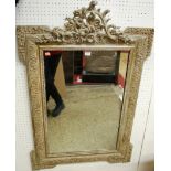 An early 20th century limed and gilt decorated wall mirror, having floral carved and pierced top