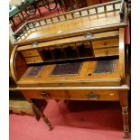 An Edwardian walnut three-quarter backed rolltop writing table, having a fitted interior, the