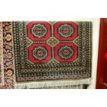 A Persian woollen pink ground Bokhara rug, 145 x 94cm