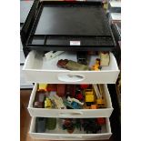 A five-tier plastic storage tray containing a quantity of mixed boxed and loose diecast models, to