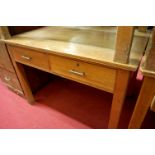 An early 20th century light oak two drawer writing table, w.106cm