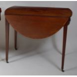 A late Georgian mahogany Pembroke table, of oval form with rosewood crossbanded top, having end