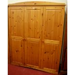 A modern pine effect three door wardrobe, together with a matching two door example (2)