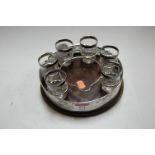 An Edwardian part liqueur set having a pierced silver mounted circular tray on oak base containing