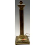 A large brass table lamp having a Corinthian capital on a fluted column and stepped square base,