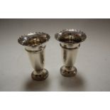 A pair of George V silver vases of trumpet shape having a wavy rim to a weighted base, height 13.