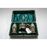An Edwardian silver three piece cruet to include pair of pepperettes and mustard, each of pierced