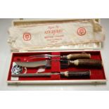 A mid 20th century three piece carving set having stag antler handles in white rexine covered fitted