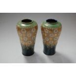 A pair of early 20th century Royal Doulton stoneware vases on a mottled blue/green ground with