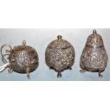 A late 19th century Eastern white metal three-piece cruet, each of squat circular form, relief