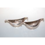 A pair of white metal boat shaped dishes, the terminals each modelled as a birds head supporting