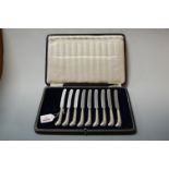 A cased set of nine butter knives, each having pistol grip silver handles (case fitted for twelve)