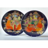 A pair of Rosenthal German porcelain chargers, each on a blue ground decorated with a figure on