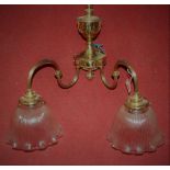 A set of three twin branched Edwardian style brass light fittings having swan necks and ribbed and