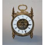 An early 20th century brass cased mantel clock having a circular enamel dial with Roman numerals and