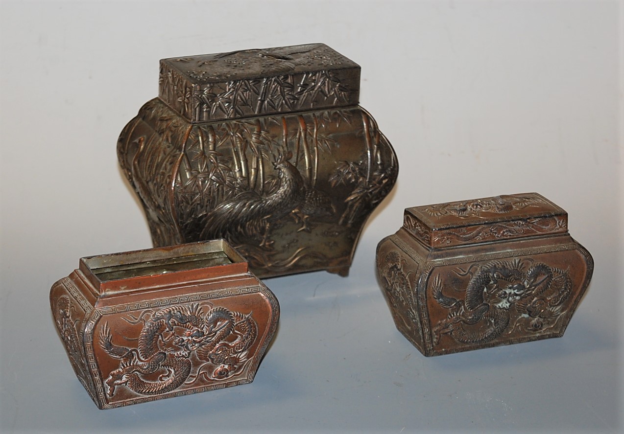 An early 20th century Chinese silver plate on copper tea caddy, of bombe form, relief decorated with