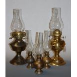 An early 20th century brass pedestal oil lamp; together with four others (5)