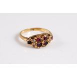 A garnet and seed pearl ring, the four round garnets set to either side with two seed pearls and a