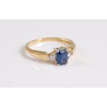 An 18ct sapphire and diamond ring, the rectangular sapphire, approx. 5.9mm long, set to either