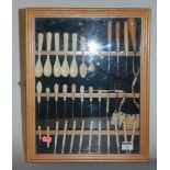 A collection of bone spoons, lace bobbins, button hooks, and sewing accoutrements, housed in a
