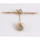 A 9ct spider and fly bar brooch, the fly set with a pear shaped blue hardstone and suspending a