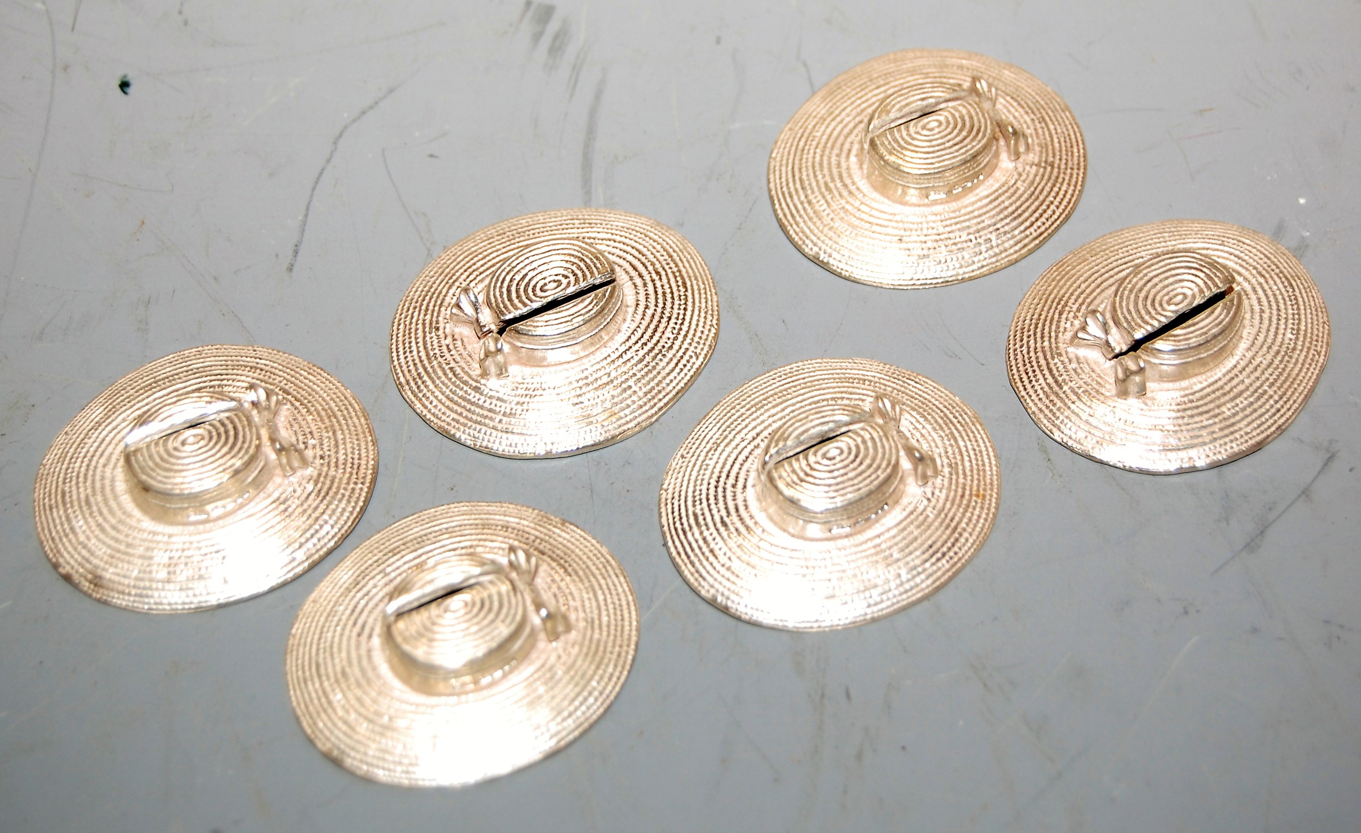 A set of six modern silver place setting holders, each in the form of a lady's hat, maker E & J,