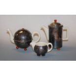 A German porcelain three-piece tea service, comprising teapot, hot water jug, and creamer, housed in