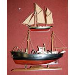 A wooden model of a trawler upon plinth together with one other smaller wooden sailing vessel