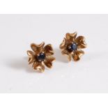 A pair of 9ct and sapphire earstuds, the central round sapphires set with four outswept petals, with
