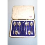A cased set of six Edwardian silver teaspoons, each having bright cut decoration, with sugar bows,