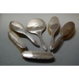A box containing five silver backed hand brushes and a silver backed hand mirror (6)