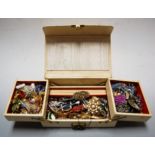 A cream leather clad jewellery box and contents to include various paste set brooches etc,