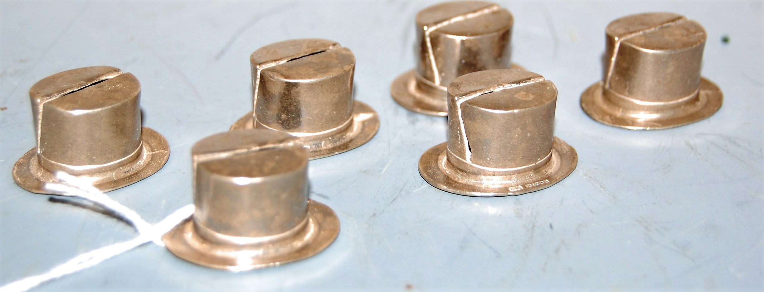 A set of six modern silver place setting holders, each in the form of a top-hat, maker E & J,