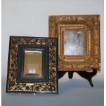 A Rococo style wall mirror, the rectangular bevelled plate within ebonised and gilt surround, relief
