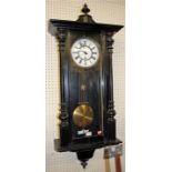 A late 19th century Vienna black painted drop trunk wall clock, having a white enamel dial