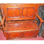 A circa 1900 geometric moulded oak twin panelled fold-over monks bench, having hinged box seat