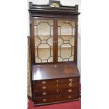 A George III mahogany bureau bookcase, having a dentil and blind carved cornice over twin astragal