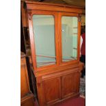 A mid-Victorian mahogany bookcase cupboard, the twin arch glazed upper doors over base fitted with