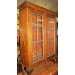 A 1930s oak and lead glazed double door bookcase, width 76cm