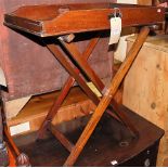 An early 19th century mahogany butler's tray raised on folding X-framed stand, the tray with twin