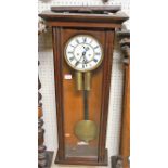 An early 20th century Vienna mahogany drop trunk wall clock, having a white enamel dial, twin