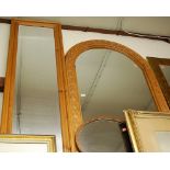 A pine framed carved wall mirror, h.123cm; one other modern pine wall mirror; and a mahogany