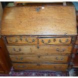 A circa 1800 provincial elm slopefront writing bureau, having two short over three long drawers,