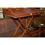 A late Georgian mahogany butler's tray on folding stand, the three raised sides with carry