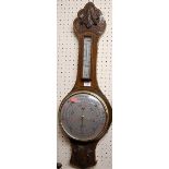 A mid 20th century relief carved oak aneroid two dial wheel barometer