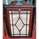 An early 19th century mahogany single door astragal glazed hanging corner cupboard