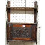 A late 19th century relief carved oak small single door hanging wall cupboard, having integral upper