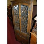 A contemporary Old Charm freestanding corner cupboard, having twin lead glazed upper doors