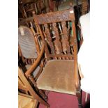 An early 20th century relief carved oak and barley twist turned slat back open armchair, width 58cm