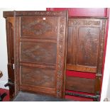 A Jacobean style relief carved oak four panelled double bedstead, having twin iron side rails